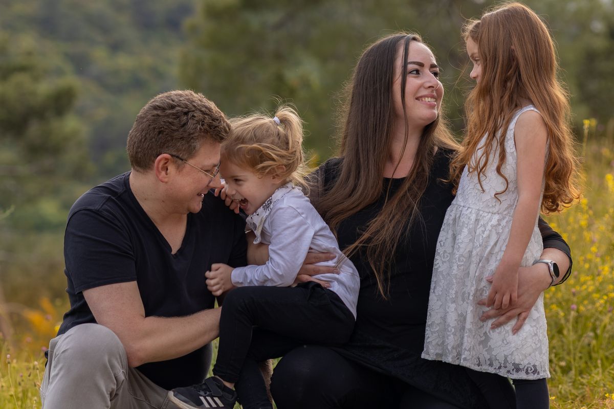 A family laughing together in a meadow