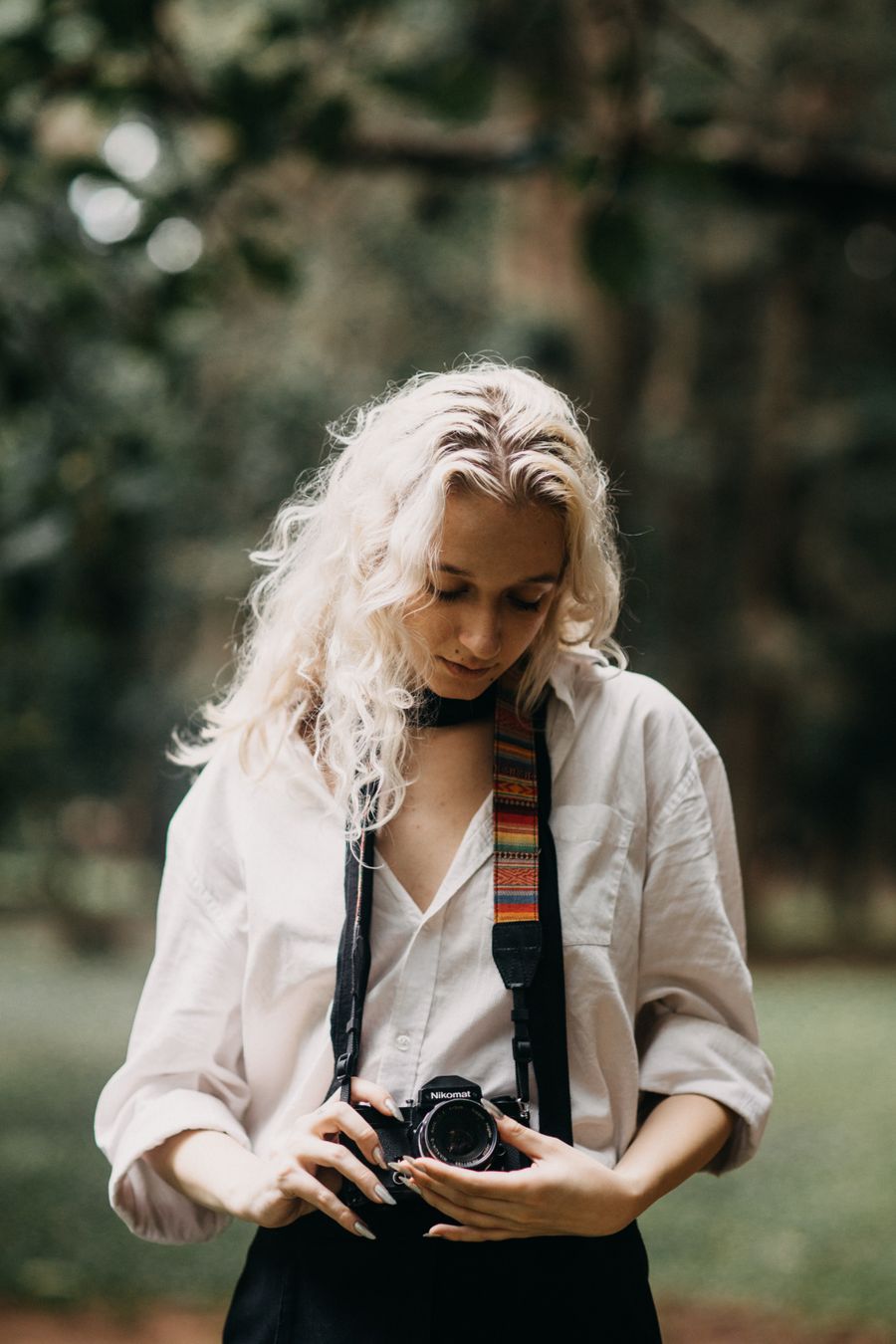 A photographer with her camera in a forest