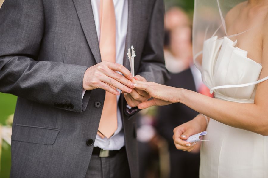 A groom putting a ring on the bride